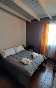 1 dormitorio con 1 cama grande y 2 toallas. en Cabañas WerMa en El Calafate
