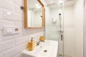 a white bathroom with a sink and a shower at Modern stylish apartment @ Superb central location in Budapest