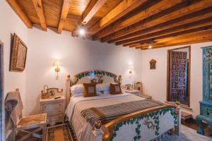 a bedroom with a large bed and a wooden ceiling at El Edén Hotel Boutique in Pátzcuaro