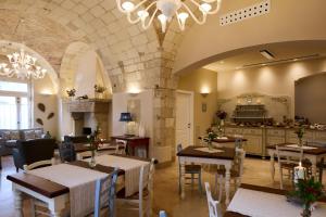 a restaurant with tables and chairs and a kitchen at Borgo San Gaetano in Bernalda
