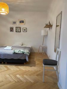 sypialnia z łóżkiem, krzesłem i lustrem w obiekcie Slow Life Apartment next to Metro Station w Warszawie