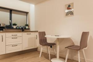 a kitchen with a table and two chairs at Aparthotel Nest Inn Meteor in Cluj-Napoca