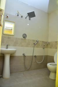ein Bad mit einer Dusche, einem Waschbecken und einem WC in der Unterkunft SAI SADHAN RESIDENCY in Chittoor