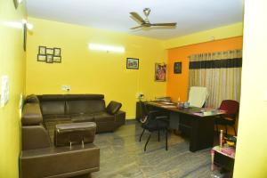 ein Wohnzimmer mit einem Sofa und einem Schreibtisch in der Unterkunft SAI SADHAN RESIDENCY in Chittoor