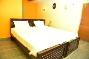 two beds in a room with orange and yellow walls at SAI SADHAN RESIDENCY in Chittoor