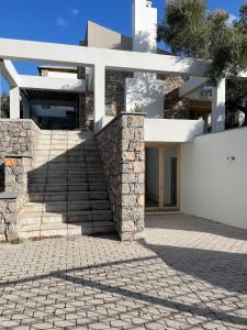 una casa con una pared de piedra y escaleras en Sunset Bay, en Drosiá