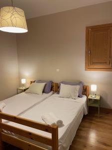 a bedroom with a large white bed with two lamps at Sunset Bay in Drosia +22 photos