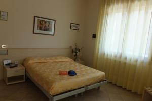 a bedroom with a bed and a large window at Hotel Nettuno in Sottomarina