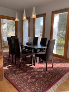 a dining room with a table and chairs on a rug at Sunset Bay in Drosia