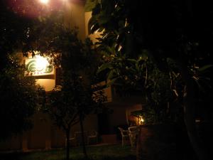 a building with chairs and a lit up sign at night at Megim Hotel in Palaiochora