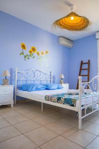 - une chambre avec un lit blanc et un mur bleu dans l'établissement Côté mer, à Marseille
