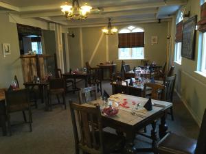 a dining room with wooden tables and chairs at The Red Lion Longwick, Princes Risborough HP27 9SG in Princes Risborough