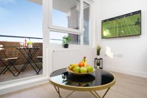 uma taça de fruta numa mesa de vidro na sala de estar em Stunning Duplex near Canary Wharf & O2 & City Views em Londres