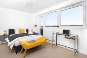 um quarto com uma cama, uma secretária e janelas em Stunning Duplex near Canary Wharf & O2 & City Views em Londres