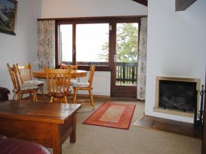 ein Wohnzimmer mit einem Tisch und einem Kamin in der Unterkunft Residence Armina in Crans-Montana