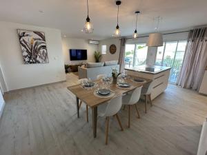 uma cozinha e sala de estar com mesa e cadeiras em Orient Bay, Appartement Héliconia. em São Martinho