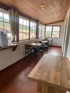 a dining room with tables and chairs and windows at Casa do Alferes in Ouro Preto