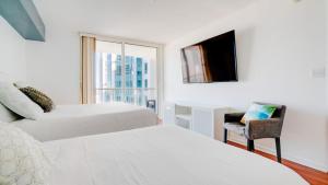 a bedroom with two beds and a chair and a window at Warm and Tailored 1BR w Pool Hot tub GYM Parking in Miami +19 photos
