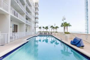 a swimming pool in a hotel with the ocean in the background at Warm and Tailored 1BR w Pool Hot tub GYM Parking in Miami