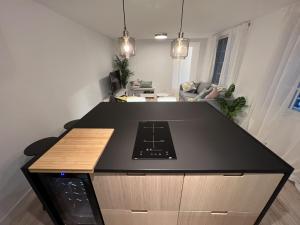 una cucina con piano di lavoro nero in una camera di Patiovecino Apartment Centro de Cádiz a estrenar a Cadice