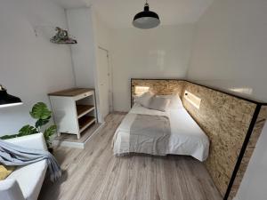 una camera con un letto e un muro in pietra di Patiovecino Apartment Centro de Cádiz a estrenar a Cadice