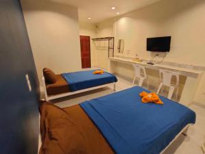 a bedroom with two beds with orange bows on them at Banana Resort Sadao in Sadao