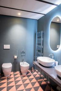a bathroom with two sinks and a toilet and a mirror at Palazzo Garibaldi - Luxury Suites in Galatina +23 photos