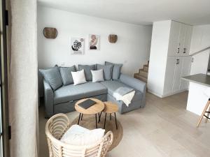 ein Wohnzimmer mit einem Sofa und einem Tisch in der Unterkunft Sonnige, neu renovierte Ferienwohnung Casa Las Fresas in Puerto Rico de Gran Canaria