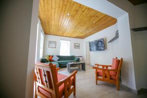 a living room with a green couch and two chairs at Legacy 1930s in Prodromos
