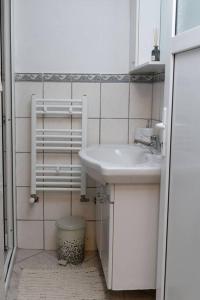 biała łazienka z umywalką i oknem w obiekcie Biniște -Tiny House by the river w mieście Dejani