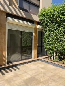 een gebouw met grote ramen en een patio bij Ground Floor Studio With Garden in Sheikh Zayed