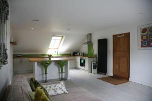 a living room with a couch and a kitchen at The Paddocks in Pilsdon