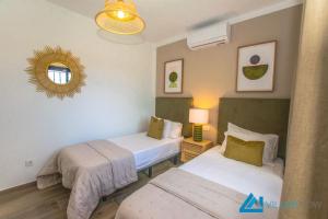 sypialnia z dwoma łóżkami i lustrem w obiekcie 222 - Villa Noches De Luna by Villas Now Ltd w mieście Playa Blanca +21 zdjęć