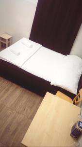 1 dormitorio con 1 cama con sábanas blancas y suelo de madera en Private Room near Vienna City Center 1, en Viena