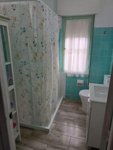 y baño con cortina de ducha y aseo. en Casa Oviedo centro en Oviedo