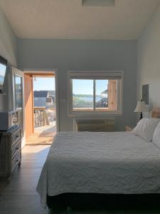 1 dormitorio con 1 cama grande y balcón en Sun and Sound Montauk, en Montauk