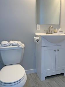 a bathroom with a white toilet and a sink at Sun and Sound Montauk in Montauk