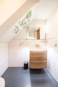 een badkamer met een wastafel en een spiegel bij Ferienwohnung mit Kuschelflair in Essen