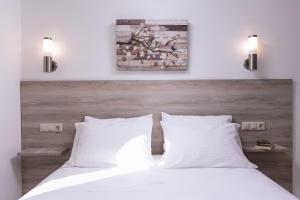 a bedroom with a white bed with two white pillows at Matala Prime Villas in Matala