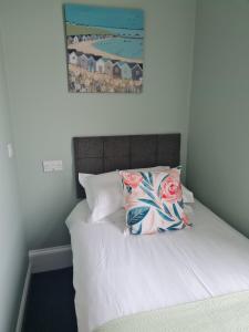 uma cama com duas almofadas e uma fotografia na parede em Kimberley House em Whitby