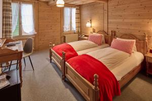 a bedroom with two beds in a wooden cabin at Baeren Hotel, The Bear Inn in Wilderswil