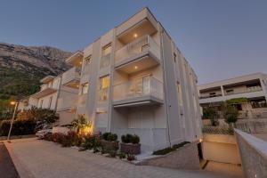 a large apartment building with a hill in the background at Villa Anchor in Baška Voda