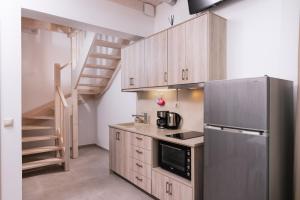 a kitchen with a stainless steel refrigerator and a staircase at Matala Prime Villas in Matala