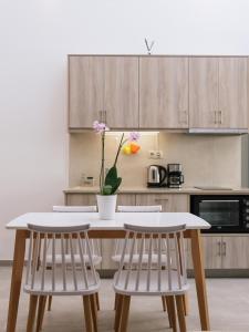 a kitchen with a table with two chairs and a vase with flowers at Matala Prime Villas in Matala