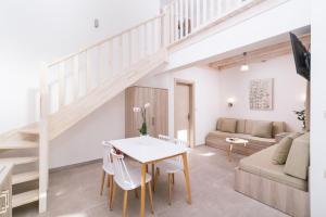 a living room with a staircase and a table and chairs at Matala Prime Villas in Matala