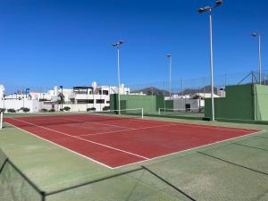 een tennisbaan met gebouwen op de achtergrond bij Casa Sol y Mar Azul un'oasi a due passi dal mare in Playa Blanca