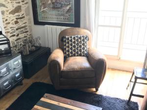 una sedia marrone con un cuscino in soggiorno di Les machines de Jules, hyper centre a Nantes Altre 45 foto