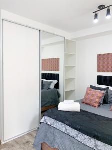 1 dormitorio con cama y espejo grande en Loft Lotus 3 - Lindo Studio na Liberdade, en São Paulo