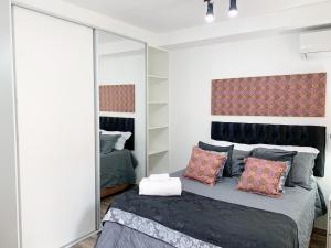 1 dormitorio con 1 cama con espejo grande en Loft Lotus 3 - Lindo Studio na Liberdade, en São Paulo