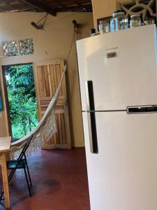 a white refrigerator in a room with a table at Casa Vila Camboinha in Itacaré